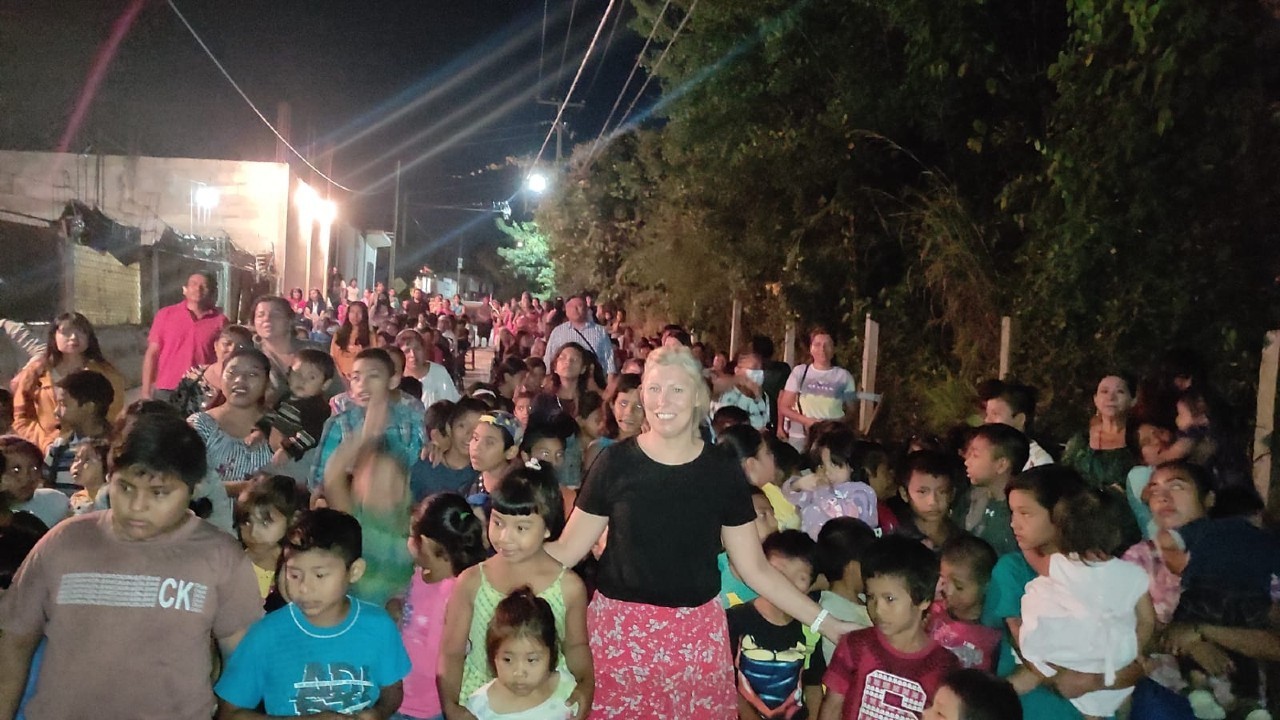 A man worshipping with a guitar surrounded by children