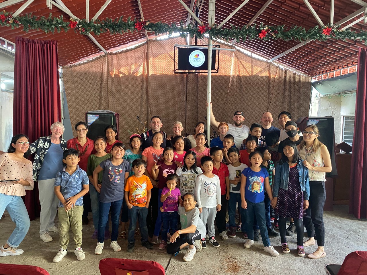 A man worshipping with a guitar surrounded by children